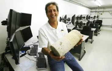 Man holding concrete cylinder in office